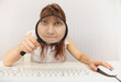 Amusing girl with computer keyboard and magnifier Amusing girl with computer keyboard and magnifier