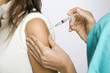 Junge Krankenschwester impft  eine Patientin