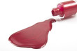 red nail polish splashed on white background