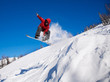 Snowboarder jumping through air with deep blue sky in background