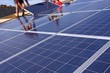 ouvriers sur un toit installant des panneaux solaires