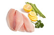Photo: raw filleted tilapia with asparagus, parsley and lemon on white raw filleted tilapia with asparagus, parsley and lemon on white