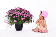 Cute baby staring at huge pot of flowers