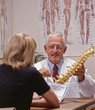 chiropractic doctor showing spine to a patient