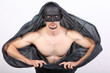 Foto: Portrait of half naked man with black mask and cape. Portrait of half naked man with black mask and cape.