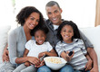 Afro-American family watching television at home