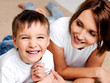 happy laughing preschooler boy with his pretty young mother