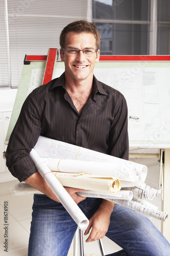 Photo: Young man with architect plans Young man with architect plans