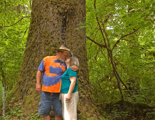 couple kissing in rain. Middle Aged Couple Kissing in Rain Forest