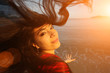 Woman with flying hair at sunset beach