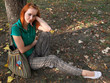 Redheaded girl sitting under the tree
