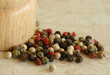 Wooden shaker and a green, red and white pepper close up