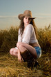Beautiful slavonic girl in cowboy clothes pose in wheat field