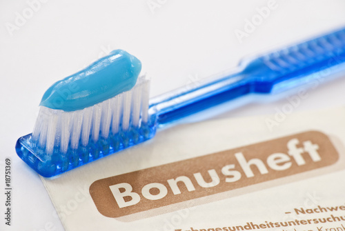 Foto: toothbrush with blue toothpaste and german bonusheft booklet toothbrush with blue toothpaste and german bonusheft booklet