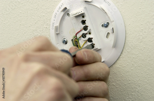 Photo: Man repairing thermostat Man repairing thermostat