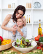 Litlle girl and her mother preparing a salad