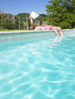 Man Reading at Edge of Swimming Pool