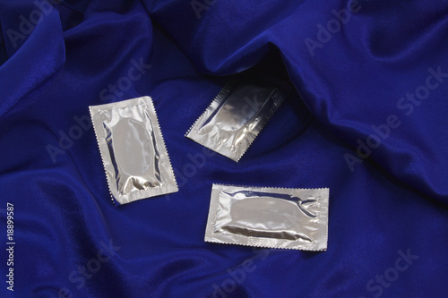 Photo: Packed Condoms on a blue satin bed. Packed Condoms on a blue satin bed.