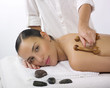 jeune femme massage dos et pierres chaudes