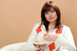 Young woman sitting in armchair with cup of tea
