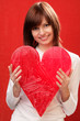 Happy woman holding big red heart on red background