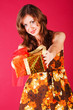 Beautiful adorable young girl in dress with a present