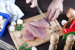 Person slicing raw pork meat