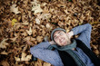 Young handsome man lying on autumn background