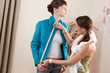 Female fashion designer measuring jacket on model Female fashion designer measuring jacket on model