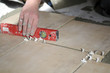 Closeup of the hand with level on the floor. Tiles installation. Closeup of the hand with level on the floor. Tiles installation.
