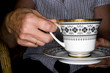Elderly hands holding a cup of tea.