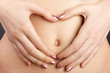 Young pregnant girl with perfect skin on black background