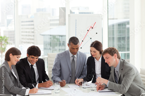 Photo: Concentrated manager and his team studying a document Concentrated manager and his team studying a document