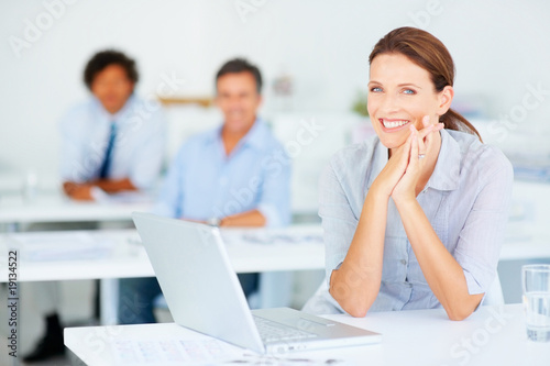 Foto: Pretty successful business woman at work, staff at the back Pretty successful business woman at work, staff at the back