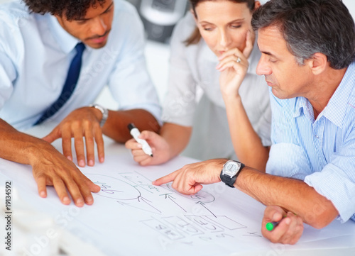 Photo: Happy magazine designers working on their profit chart Happy magazine designers working on their profit chart