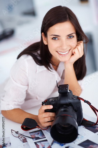 Foto: Young pretty female photographer with her camera Young pretty female photographer with her camera