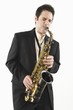 Mid adult man stands in suit playing the saxophone