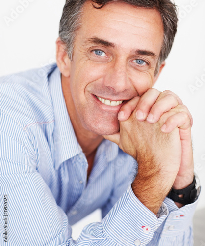 Photo: Closeup of a happy mature magazine editor while at work Closeup of a happy mature magazine editor while at work