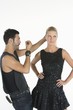Hair stylist makes adjustments to model standing with hands on hips