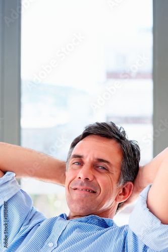 Photo: Closeup of a happy mature magazine editor while at work Closeup of a happy mature magazine editor while at work