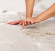 Human hand in scripting the sand on the beach