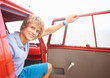 Cute young guy smiling by the door of the mini van