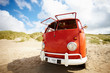 Vintage red mini van isolated on a beach