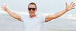 A young boy wearing sunglasses with his hands outstretched
