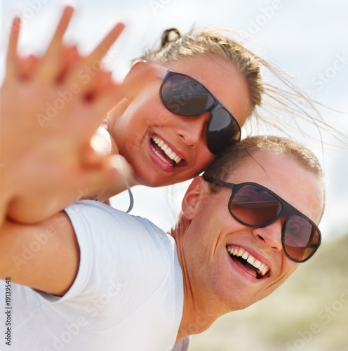Foto: Cute teenaged girl being piggybacked by a friend at the beach Cute teenaged girl being piggybacked by a friend at the beach