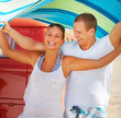 Foto: Charming couple holding a towel above their head Charming couple holding a towel above their head