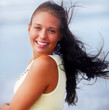 Foto: A pretty young brunette smiling at the beach A pretty young brunette smiling at the beach