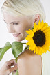 A Young Woman With A Sunflower Resting On Her Shoulder