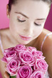 A Young Woman Smelling A Bunch of Pink Roses