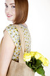 A Young Woman Carrying A Bunch Of Yellow Roses In A Shopping Bag